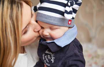 Woman Kissing Baby — St. Paul, MN — Corner Home Medical