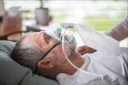Man Lying in Bed with an Oxygen Mask — Hutchinson, MN — Corner Home Medical